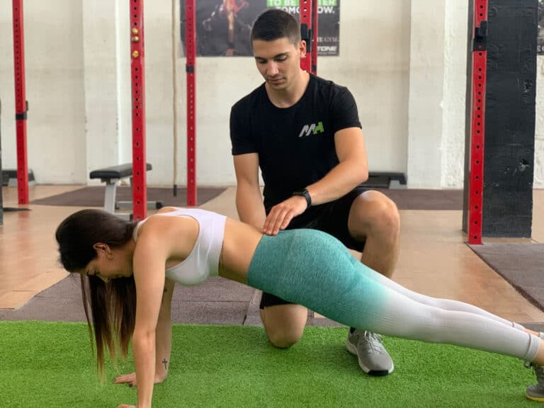 mujer realizando un entrenamiento individual en gimnasio con entrenador personal en zaragoza